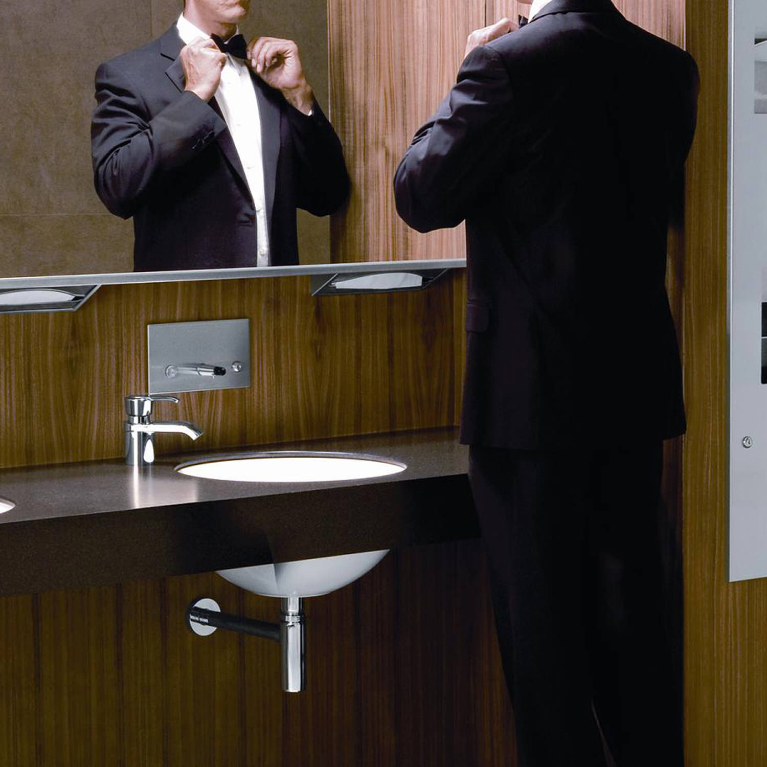 Recessed paper towel dispenser behind mirror in stainless steel